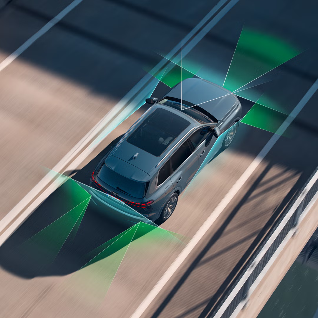 Der Audi Q7 SUV von schräg oben auf einer Brückenstraße. Vom Heck und der Front aus unterteilen grüne und blaue Vektoren die Flächen hinter und vor dem Fahrzeug.